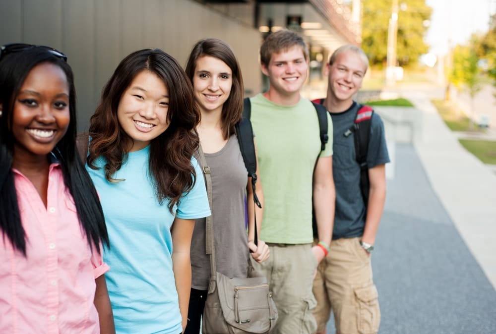 A group of teenagers posing with bright smiles.
