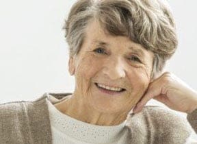 Elderly lady posing with a bright smile, displaying her healthy white teeth at Pike District Smiles.