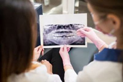 Dentist showing dental results on X-rays to her patient at Pike District Smiles.