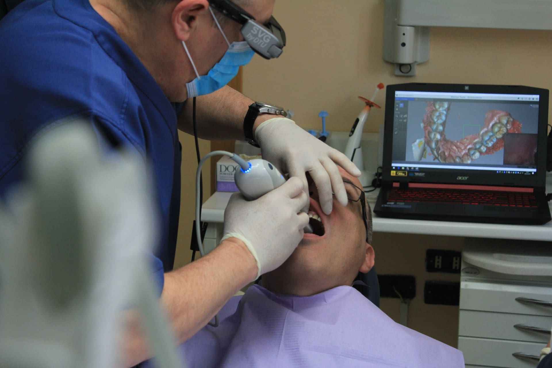 Dentist placing dental instrument in the mouth of the patient during dental treatment.